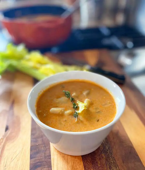 A bowl of soup on top of a wooden table.