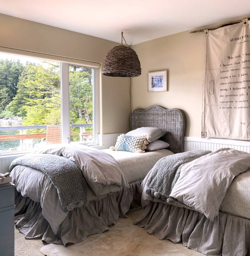 A bedroom with two beds and a large window.