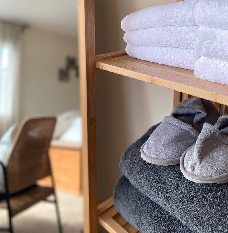 A shelf with slippers and towels on it.