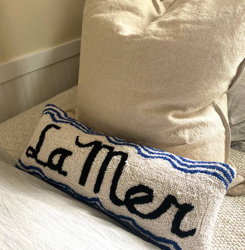 A pillow that says " la mer ".