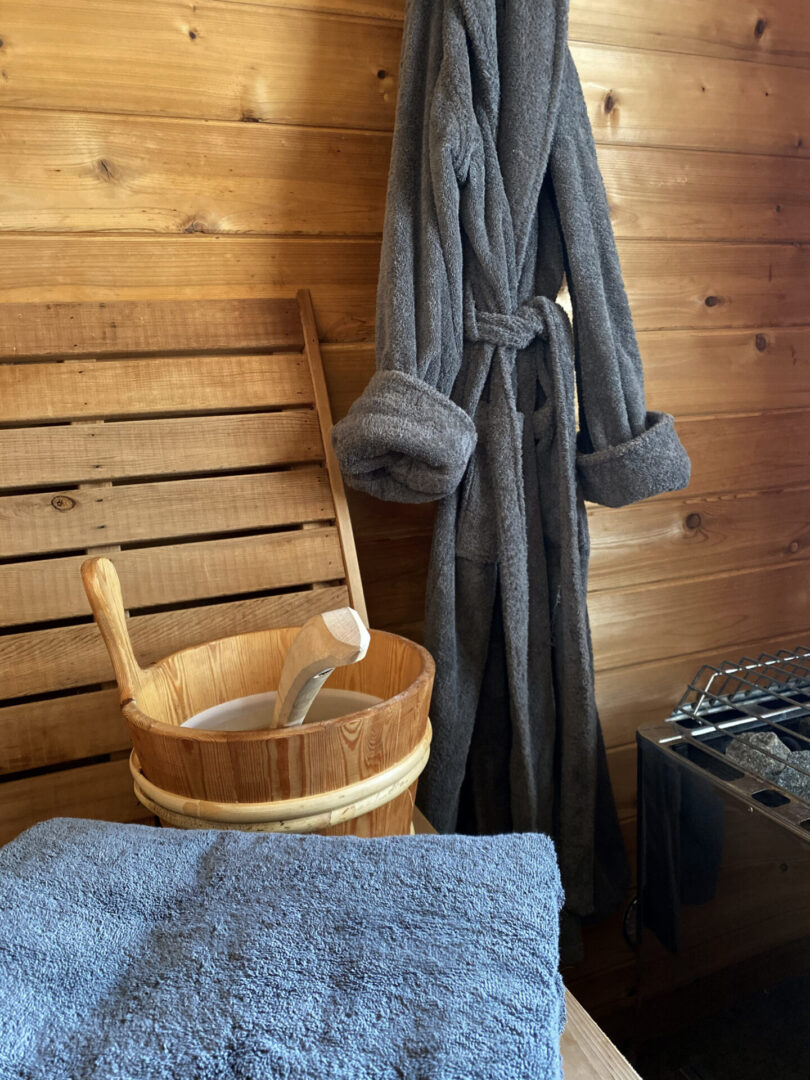 A wooden tub with a bucket of water and towels.