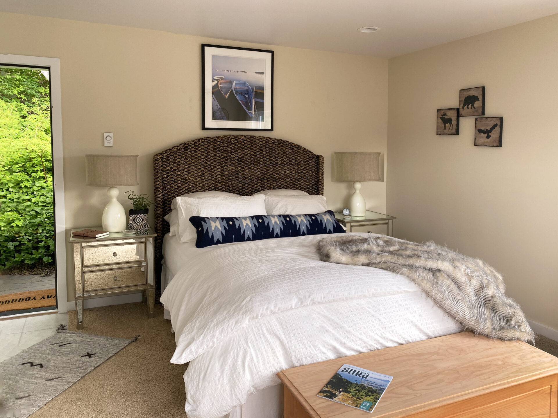 A bedroom with a bed, nightstand and table.